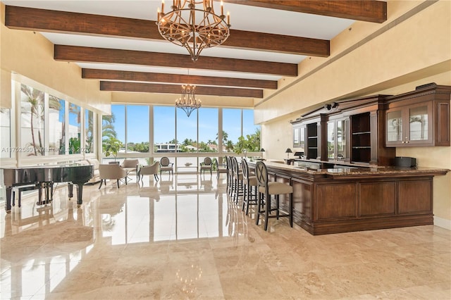 interior space with beamed ceiling, plenty of natural light, and a notable chandelier