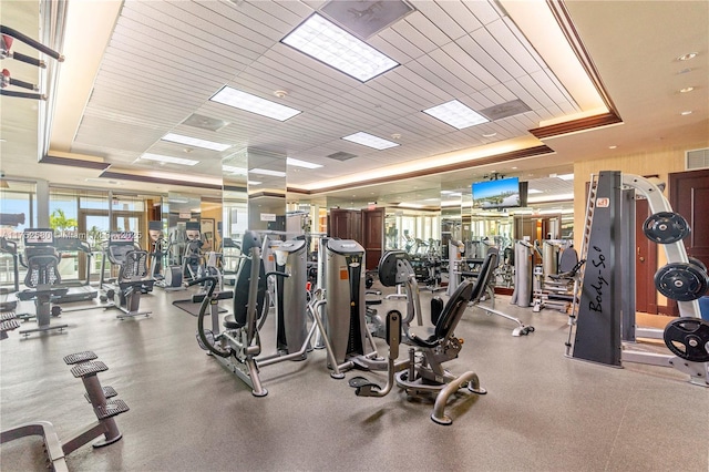 workout area featuring a tray ceiling and visible vents