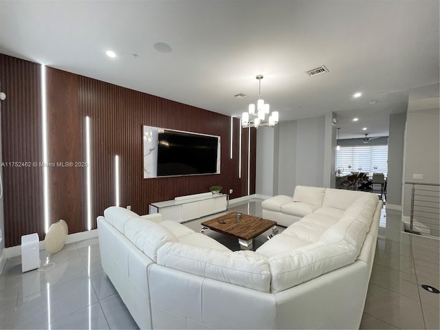 living room featuring light tile patterned floors, recessed lighting, visible vents, an accent wall, and a chandelier