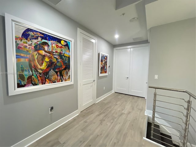 corridor with light wood-style floors and baseboards