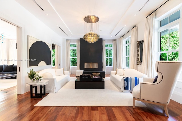 living room with a fireplace, a notable chandelier, and wood finished floors