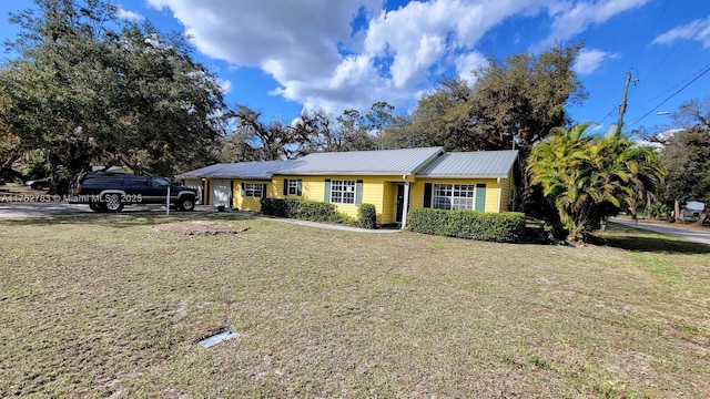 ranch-style house with metal roof and a front lawn