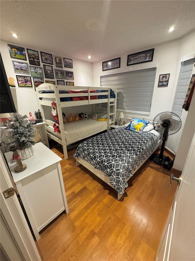 bedroom featuring light wood-style flooring, a textured ceiling, and recessed lighting