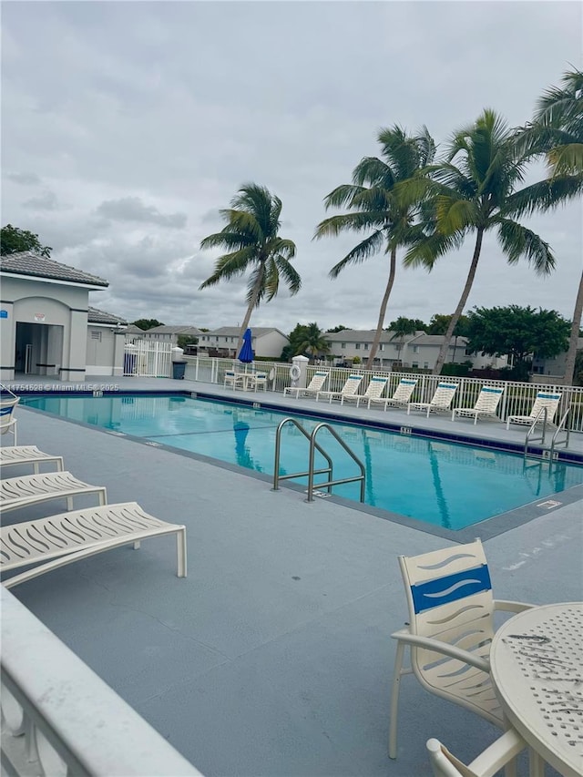 pool with a patio and fence