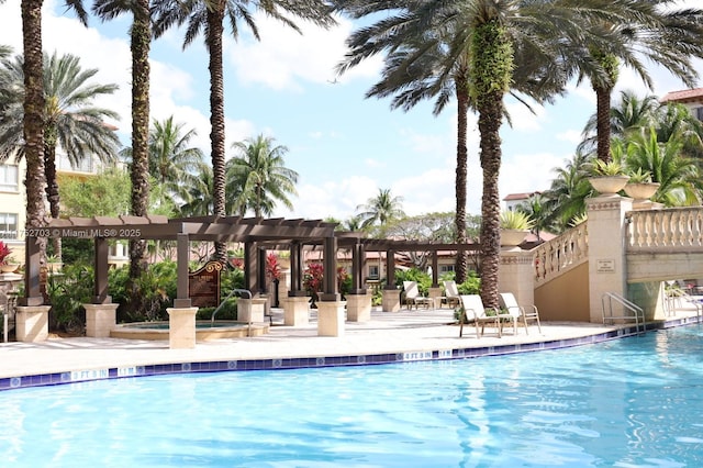 community pool with a patio area, a jacuzzi, and a pergola