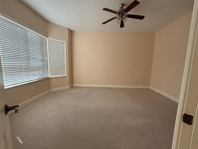 empty room featuring a ceiling fan, carpet, and baseboards