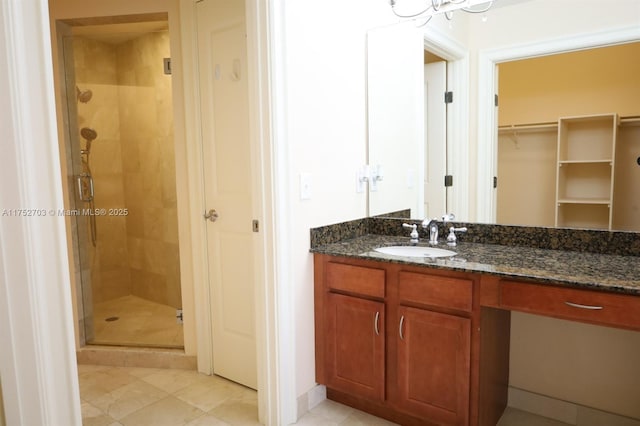 bathroom with a shower stall, vanity, and a spacious closet