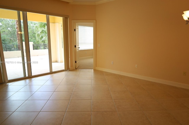 spare room featuring light tile patterned floors and baseboards