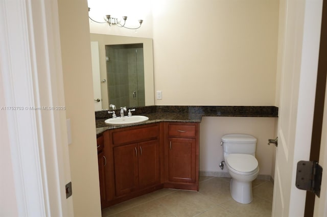 bathroom featuring baseboards, toilet, tile patterned floors, a tile shower, and vanity