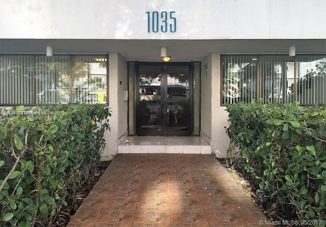 property entrance featuring stucco siding and french doors