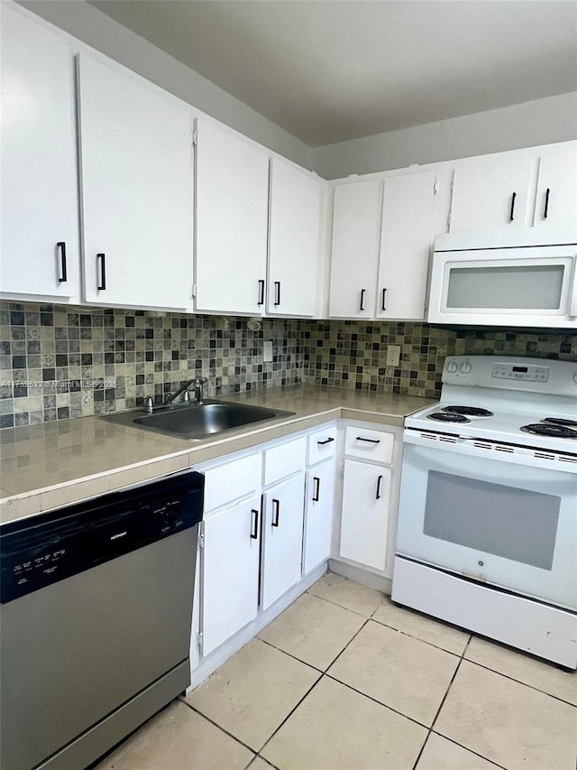 kitchen featuring light countertops, decorative backsplash, white cabinetry, a sink, and white appliances