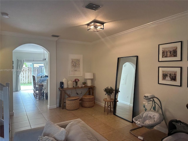 living room with arched walkways, visible vents, crown molding, and light tile patterned flooring