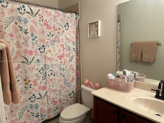 full bath with curtained shower, vanity, and toilet