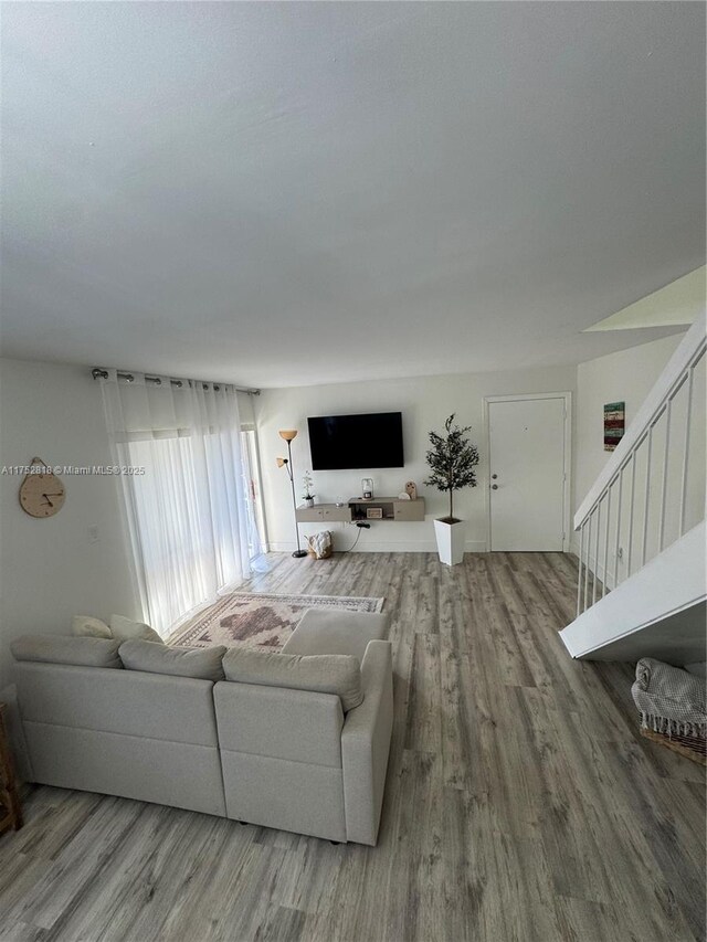 living area with wood finished floors and stairway