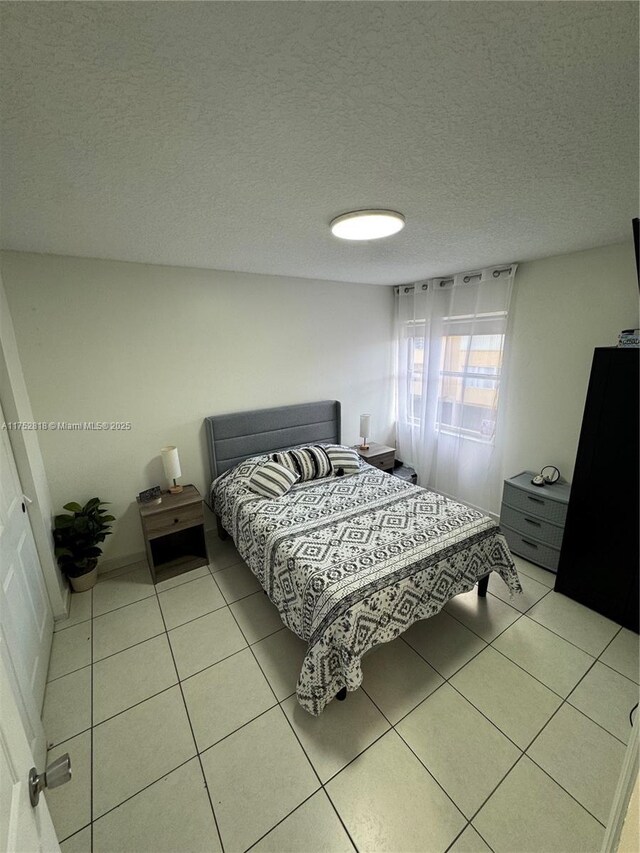 bedroom with light tile patterned flooring and a textured ceiling