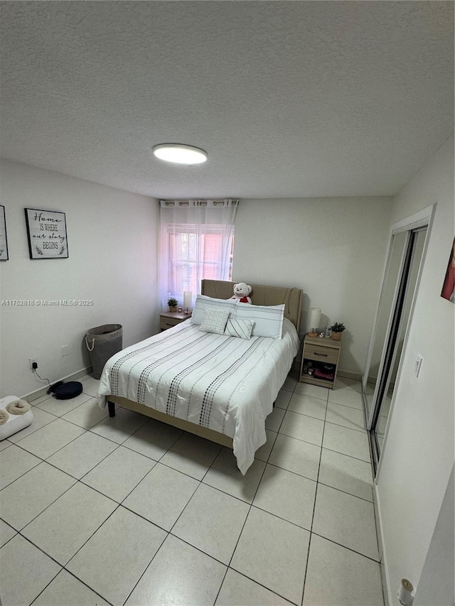 bedroom with light tile patterned flooring and a textured ceiling