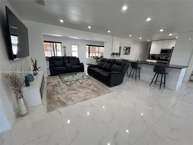 living room with marble finish floor, visible vents, and recessed lighting