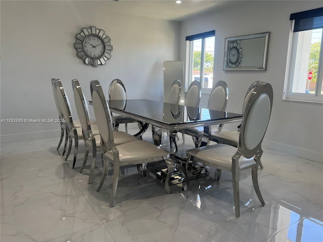 dining area featuring marble finish floor and baseboards