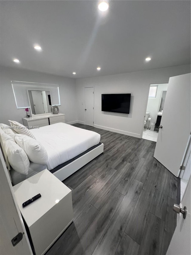 bedroom with baseboards, ensuite bath, dark wood finished floors, and recessed lighting