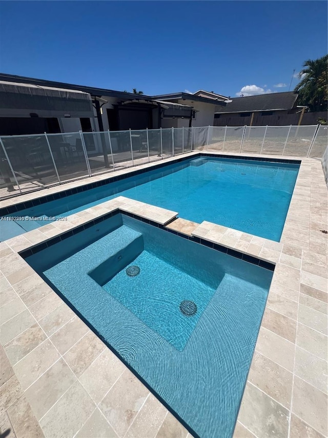 view of pool featuring a pool with connected hot tub and fence