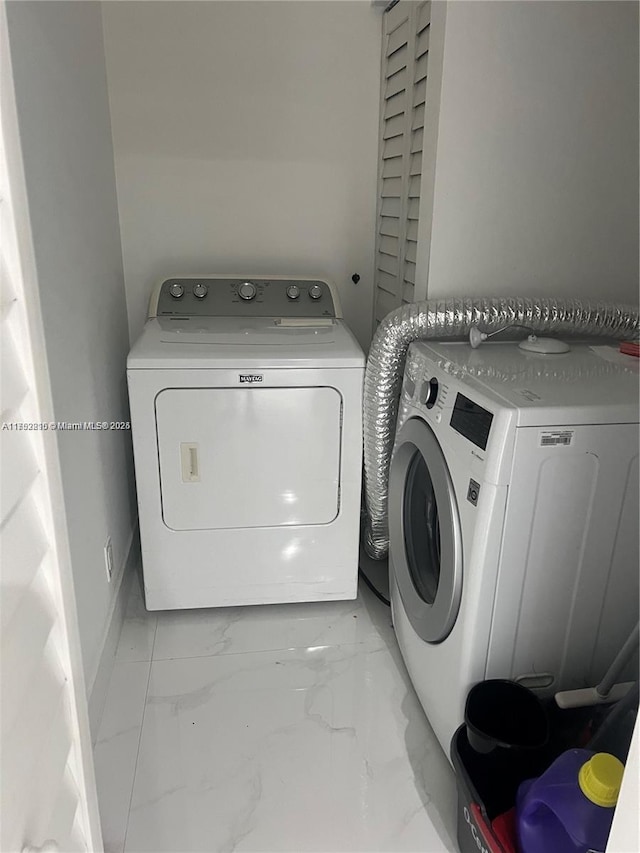 laundry room with marble finish floor, baseboards, laundry area, and washer and dryer