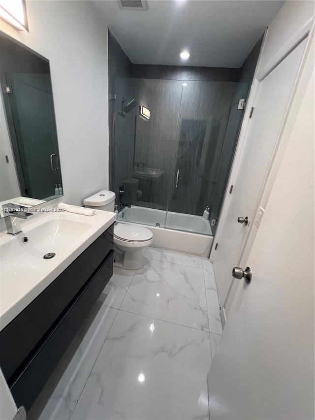 full bath with toilet, marble finish floor, enclosed tub / shower combo, and vanity