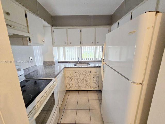 kitchen featuring light tile patterned floors, white cabinets, a sink, white appliances, and under cabinet range hood