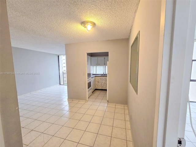 unfurnished room featuring light tile patterned floors and a textured ceiling