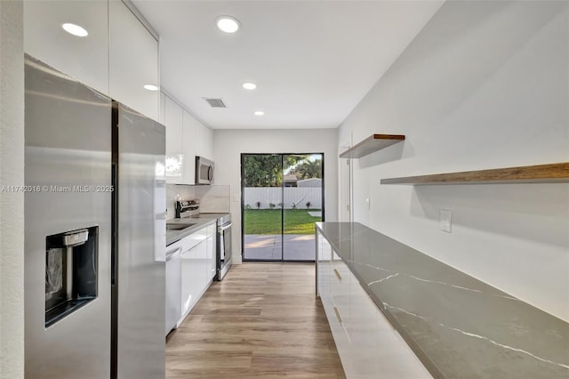 kitchen featuring appliances with stainless steel finishes, modern cabinets, white cabinets, and open shelves