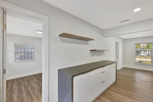 kitchen featuring open shelves, dark countertops, visible vents, white cabinets, and modern cabinets