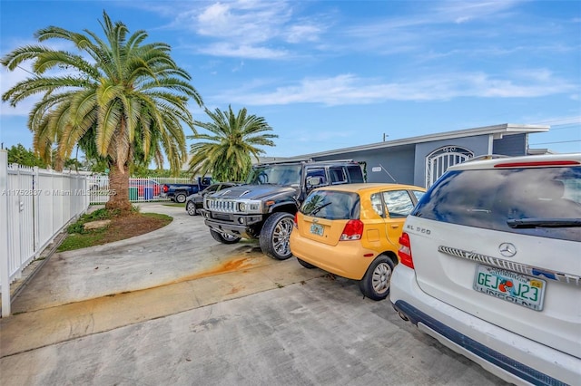 uncovered parking lot featuring fence