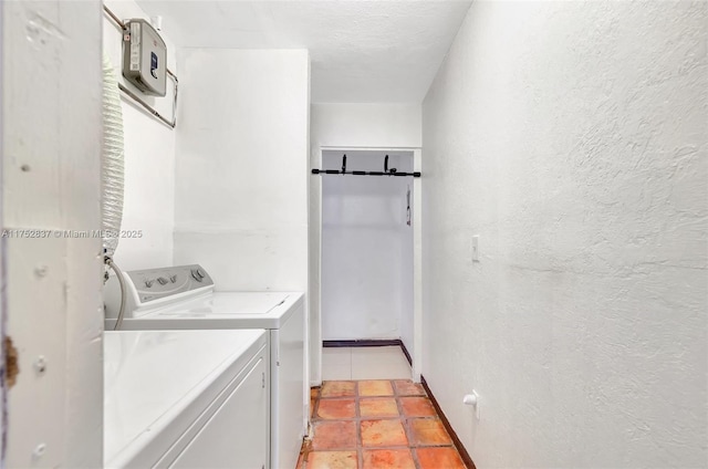 washroom with laundry area, light tile patterned floors, a textured wall, independent washer and dryer, and a textured ceiling