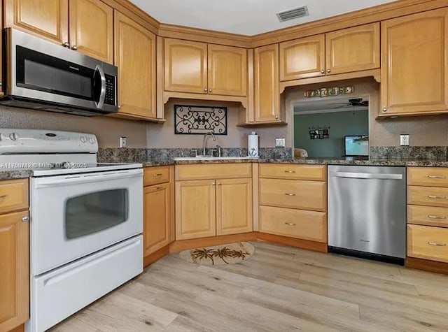 1860 Waterford Dr Unit 253, Vero Beach, FL 32966 - kitchen with a sink, dark stone countertops, stainless steel appliances, visible vents, and light wood-style floors