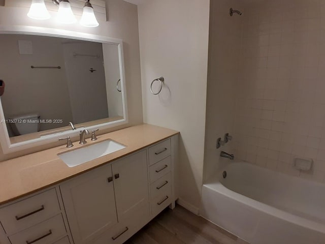 full bath featuring vanity, wood finished floors, and bathing tub / shower combination