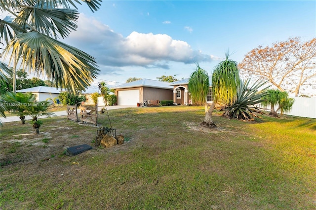 view of yard featuring an attached garage and fence