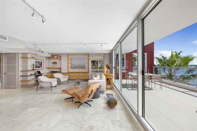 interior space featuring floor to ceiling windows, visible vents, and track lighting