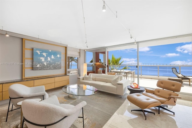 living room featuring expansive windows, a water view, and track lighting