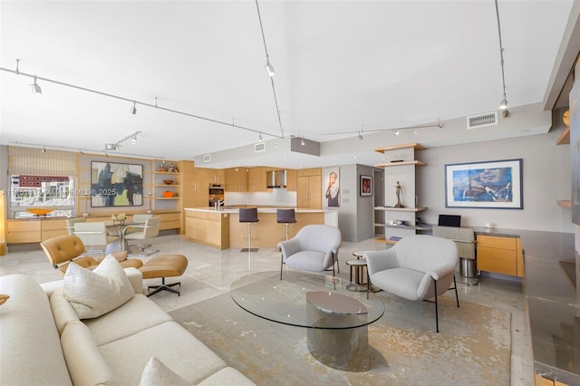 living room featuring rail lighting, visible vents, and built in features