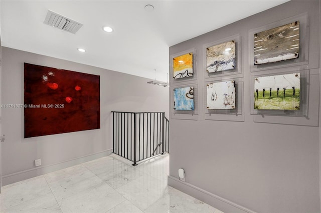 corridor with marble finish floor, baseboards, and visible vents