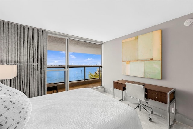 bedroom with a water view and baseboards