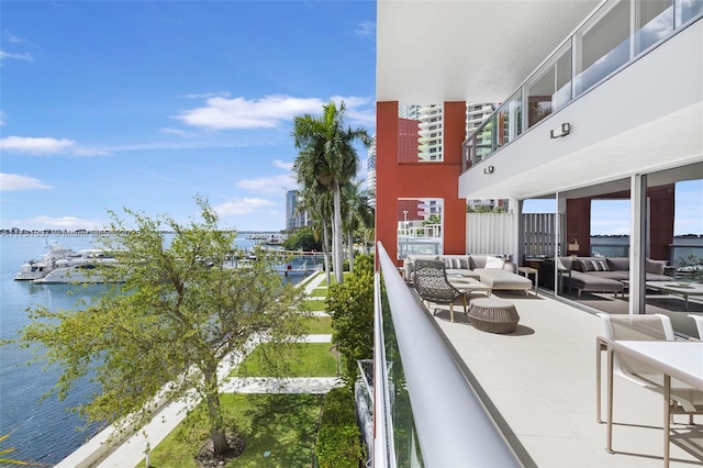 balcony featuring a water view and an outdoor living space