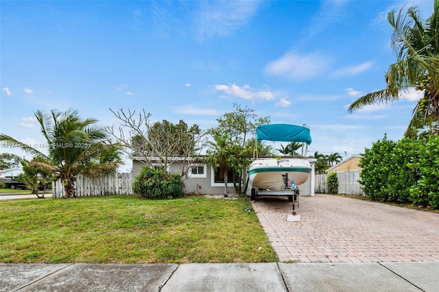 5801 NE 3rd Ave, Oakland Park, FL 33334 - view of front facade with a front yard, decorative driveway, fence, and stucco siding