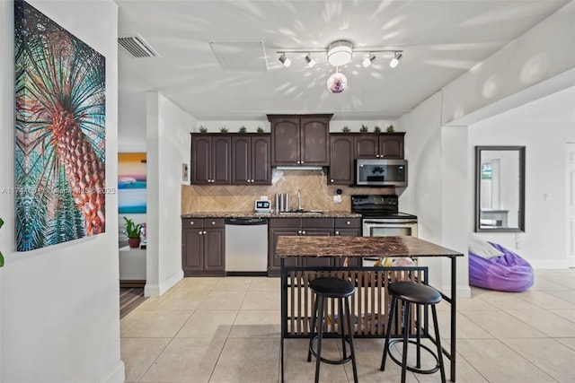 5801 NE 3rd Ave, Oakland Park, FL 33334 - kitchen with dark countertops, dark brown cabinetry, visible vents, and appliances with stainless steel finishes