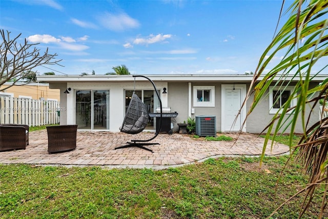 5801 NE 3rd Ave, Oakland Park, FL 33334 - back of property featuring central AC, a lawn, a patio, and stucco siding
