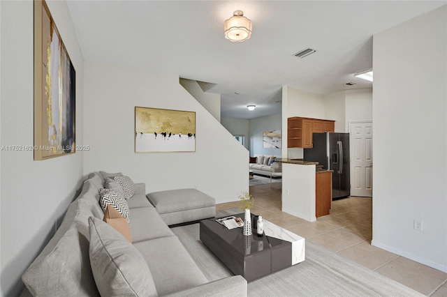 living area featuring visible vents, baseboards, and light tile patterned floors