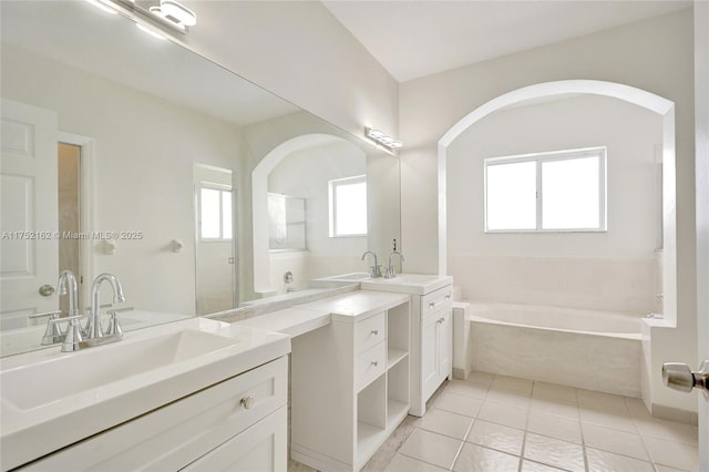 bathroom with a bath, two vanities, a sink, and tile patterned floors