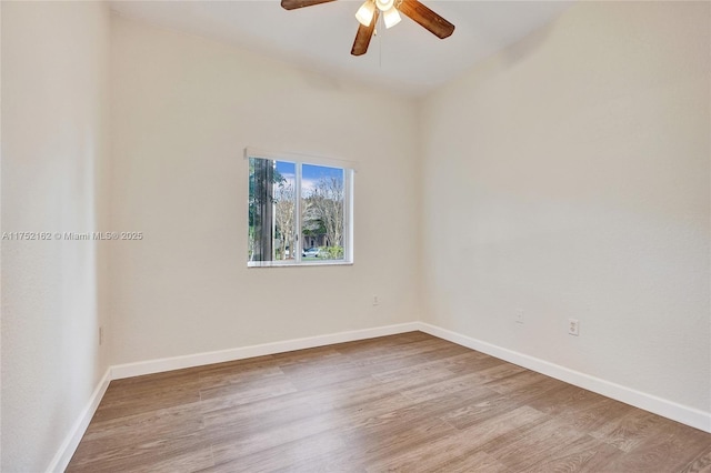 spare room featuring light wood-style floors, baseboards, and a ceiling fan