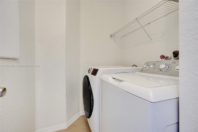 laundry room featuring laundry area, independent washer and dryer, light tile patterned flooring, and baseboards