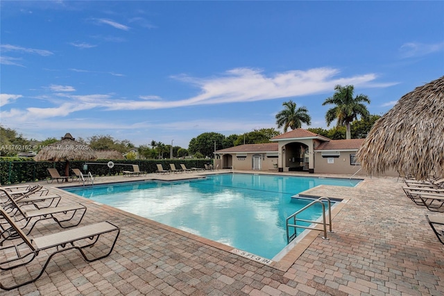 pool with a patio area and fence