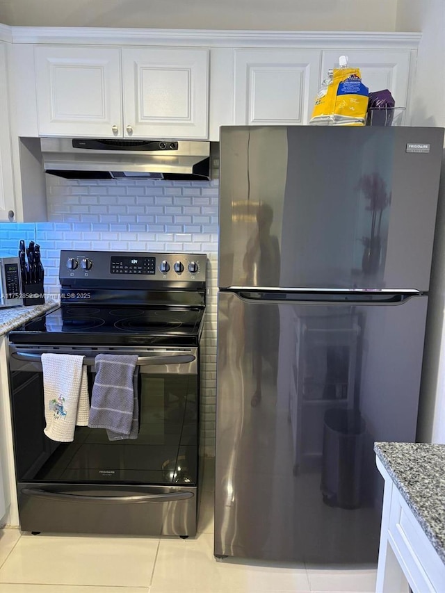 kitchen featuring decorative backsplash, appliances with stainless steel finishes, light stone counters, under cabinet range hood, and white cabinetry